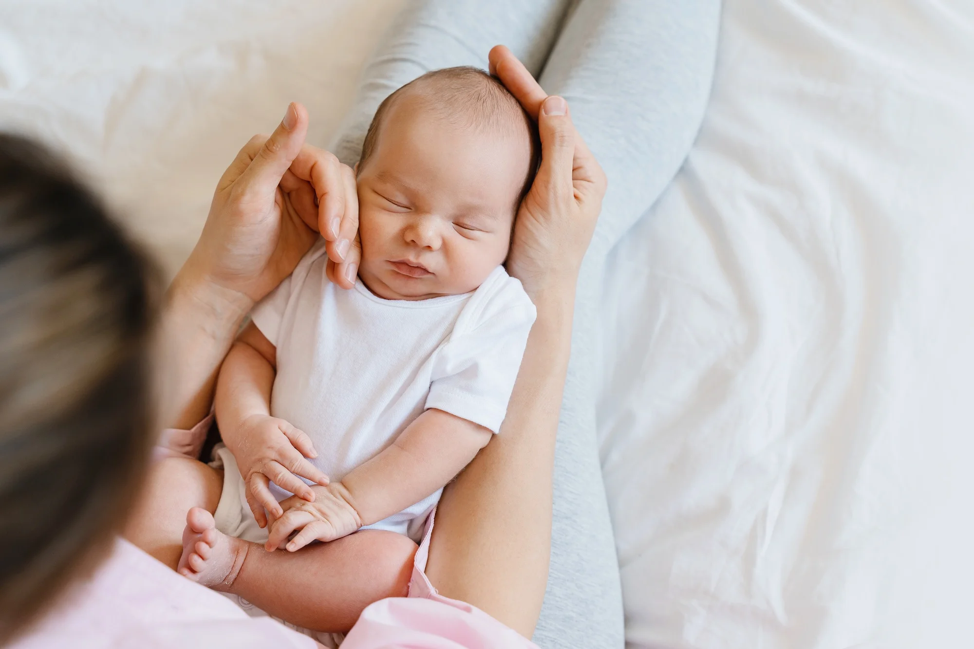 Baby sleeping in arms of his loving mother. Baby care.